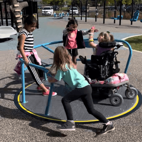 an inclusive playground spinner with kids of all abilities playing